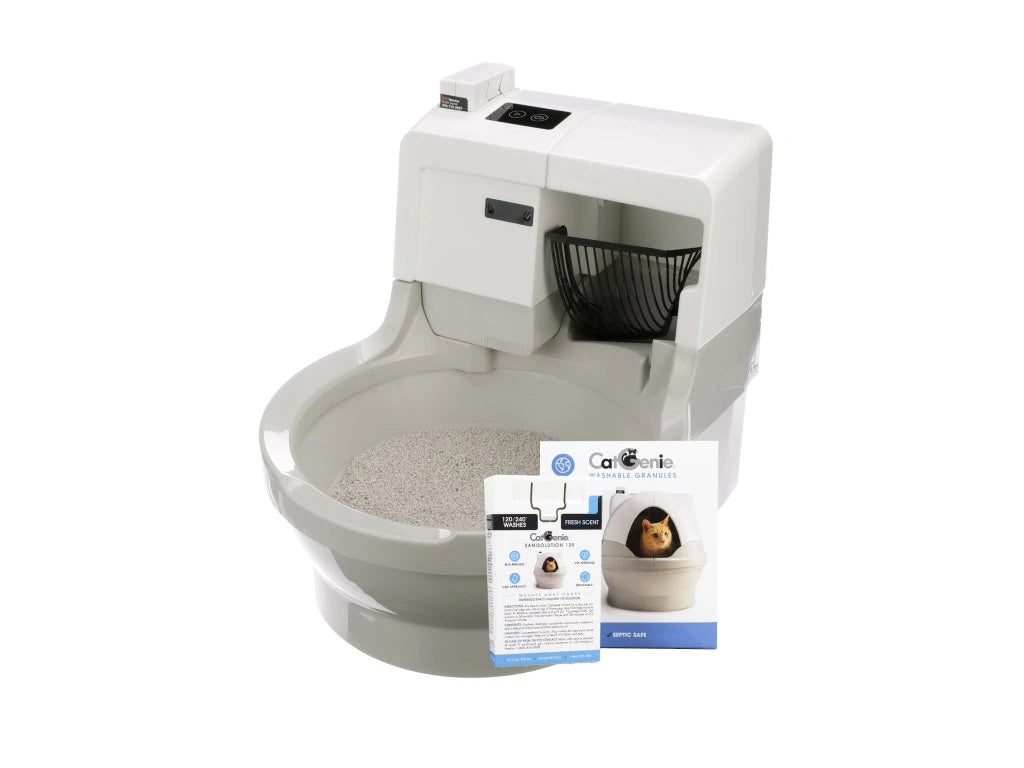 Die CatGenie A.I. ohne GenieDome ist eine weiße, selbstreinigende Katzentoilette; vor ihr liegt eine Broschüre mit dem Bild einer Katze im Inneren der Box.